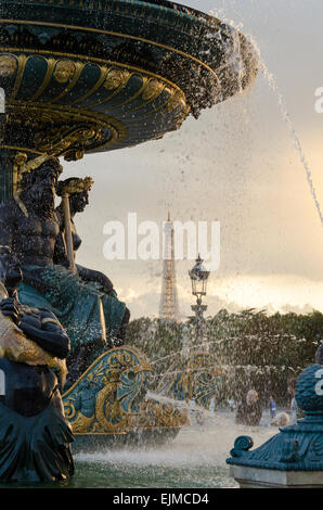 Un coucher du soleil août allume la Fontaine des fleuves de la Place de la Concorde, Paris, France, avec la Tour Eiffel au-delà. Banque D'Images