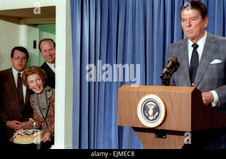 Du président américain Ronald Reagan lors d'une conférence de presse dans la salle de briefing de la Maison Blanche en tant que première dame Nancy Reagan et David Gergen préparer une fête surprise pour l'anniversaire en l'honneur du Président 71e anniversaire le 4 février 1983 à Washington, DC. Banque D'Images