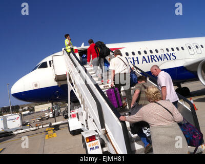 Étapes de BRITISH AIRWAYS British Airways les passagers d'un avion par étapes pour cabine avant l'exécution des bagages à main dans des conditions de ciel bleu ensoleillé Banque D'Images