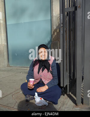 Vieille Femme assise sur le sol, la mendicité en dehors du marché de la Boqueria sur Las Ramblas à Barcelone, Catalogne, Espagne Banque D'Images