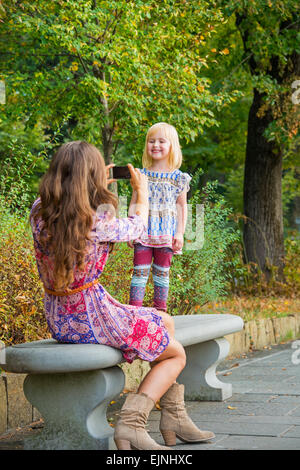 Mère et bébé girl taking photo dans city park Banque D'Images