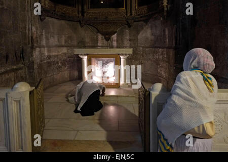 Un chrétien orthodoxe éthiopien s'agenouille dans la prière à la chapelle orthodoxe grecque de la dérision ou à la chapelle du couronnement des Thorns à l'intérieur de l'église Saint-Sépulcre dans le quartier chrétien de la vieille ville est de Jérusalem Israël Banque D'Images
