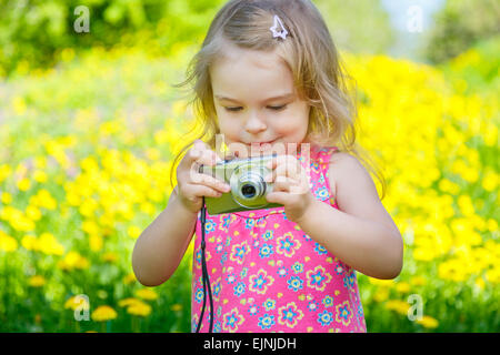 Petite fille à prendre des photos sur un pré Banque D'Images