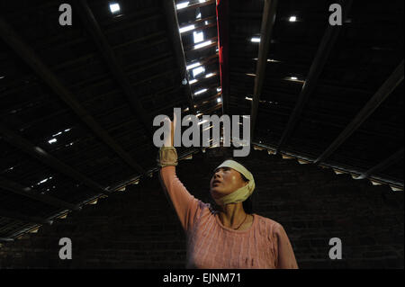 Jianhe, province du Guizhou en Chine. 30Th Mar, 2015. Wu Guangqin, atteint par jeu pendant le tremblement de terre, de points à un toit endommagé à Xinliu Village de Jianhe, comté de la province du Guizhou, au sud-ouest de la Chine, le 30 mars 2015. Un séisme a frappé d'une magnitude de 5,5 Jianhe County dans le sud-ouest du Guizhou le lundi. Plus de 13 000 habitants de 2 200 ménages de Jianhe ont été touchées par le tremblement de terre, selon le ministère des affaires civiles de la province. Credit : Ou Dongqu/Xinhua/Alamy Live News Banque D'Images