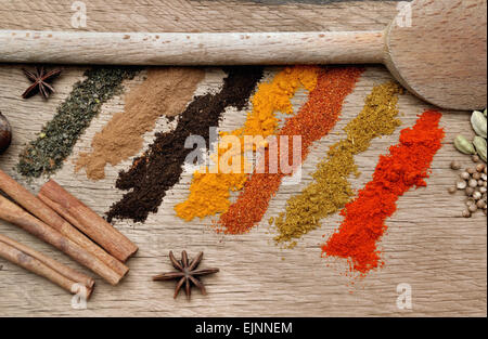 Bandes de différentes épices, d'anis et de cardamome en poudre et la cuillère sur fond de bois Banque D'Images