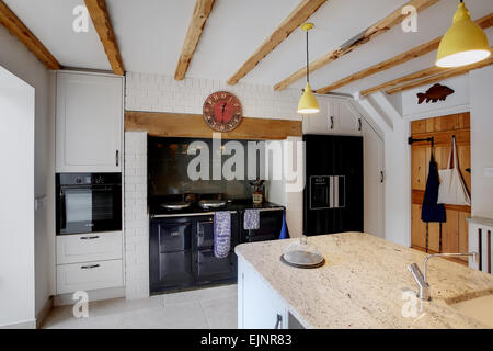 Une cuisine de style traditionnel à l'intérieur d'une ferme dans le Royaume-Uni avec une cuisinière Aga noir. Banque D'Images