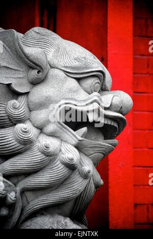 Ancienne en pierre traditionnelle sculpture lion chinois situé dans un quartier historique de la ville Banque D'Images