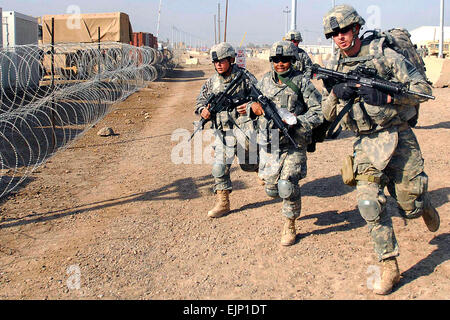 La FPC. James, Nikkels de Pitman, N.J., un instructeur de la CLS et bien sûr d'autres soldats au 47e Bataillon de soutien de l'avant, 2e Brigade Combat Team, 1re Division blindée, Multi-National Division-Baghdad, exécuter à une attaque simulée dans l'exercice de leur simulation de combat final sur le camp de la gâche, l'Iraq, le 28 novembre. Banque D'Images