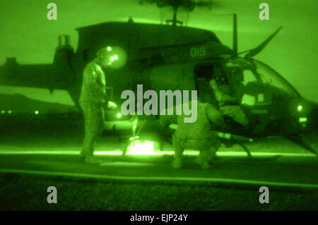 Deux 2e Escadron, 6e régiment de cavalerie, 25e Brigade d'aviation de combat, les soldats travaillent ensemble pour réarmer un OH-58 Kiowa Warrior avec des roquettes durant la nuit et les opérations de tir aérien à l'Pohakuloa FARP Zone d'entraînement, le 5 février. Banque D'Images