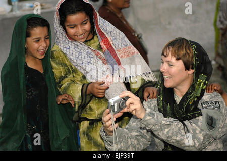 Le capitaine de l'armée américaine Marie Orlando montre les filles de photos au cours de leur réunion hebdomadaire d'Eclaireuses à base d'Finley-Shields, l'Afghanistan, le 9 octobre 2010. Orlando est l'officier des opérations de l'information avec l'équipe de développement de l'agriculture affectés à la base. Orlando est de porter le patch de la Garde nationale du Missouri. En savoir plus sur eux à www.moguard.com www.moguard.com . Le sergent-chef. Bill Gomez, U.S. Air Force. Banque D'Images