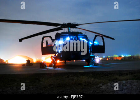 Une exposition prolongée présentent des traînées de lumière à partir de la route d'un 10e Brigade d'aviation de combat Black Hawk UH-60M de l'équipage de l'hélicoptère lors d'une inspection prévol de l'aéronef avant de lancer un mouvement sur le personnel de la mission le 8 décembre, à la base d'opérations avancée Fenty, Afghanistan. Le capitaine de l'armée américaine Peter Smedberg Banque D'Images