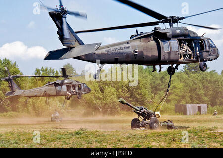 Les hélicoptères Black Hawk UH-60 airlift howitzers de 105 mm à un endroit prédéterminé à Fort Drum, N.Y., 18 juillet 2012. Les soldats sont affectés au 1er bataillon du 258e d'artillerie sur le terrain ; l'équipage de l'hélicoptère est affecté à l'aviation de l'Armée de soutien 3 Latham, NY Le Sgt. 1re classe Steven Petibone Banque D'Images