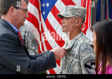 Secrétaire adjoint de la Défense, Ash Carter les bornes a Purple Heart médaille sur le s. de l'armée. Jerry M. Amis lors d'une cérémonie à la Purple Heart Warrior and Family Support Center sur Joint Base San Antonio-Fort Sam Houston, Texas, le 29 octobre 2013, en tant que femme, des amis, Nerrisha les regarde. L'amis a été blessé le 3 septembre 2013, lorsque son véhicule a été touché par un engin explosif improvisé lors d'une patrouille en Afghanistan. Carter s'est rendu avec plusieurs guerriers aux patients hospitalisés au centre médical. Robert Shields Banque D'Images