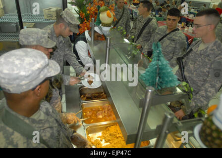 Le Capitaine James Williams loin, de Chapel Hill, N.C., le Major James Lantz, de Cranston, N.J., et 1er Sgt. De Rahim Jones, du siège et de l'entreprise de l'Administration centrale, 1er Bataillon des troupes spéciales, 1e Brigade Combat Team, 4e Division d'infanterie, Multi-National Division-Baghdad, servir le dîner de Noël pour les soldats déployés à la base d'opération avancée Falcon, l'Iraq. Lantz est une réserve de l'armée américaine des affaires civiles, attribuée à la société D, 404e Bataillon des affaires civiles, à Fort Dix, New Jersey. Soldats de la 1re Brigade apprécié "Raider" la Turquie, les côtes et l'ensemble des fixations de vacances au Raider Cafe Banque D'Images