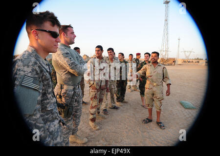 Des soldats américains affectés à la Compagnie Bravo, 1er bataillon blindé, 63e régiment blindé, 2e Brigade Combat Team, 1re Division d'infanterie et les soldats forment l'armée iraquienne affectée à la 17e Division IA concurrence dans un match de foot au peuple iraquien dans Qarghuli Dragon composé, de l'Iraq le 13 avril. Banque D'Images