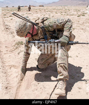 Le Sgt. 1re classe Alan Sutton, un chef de peloton avec 1ère Brigade Combat Team, 82e Division aéroportée, recherche d'un fil de commande d'un engin explosif improvisé le 1 août, la province de Ghazni, Afghanistan. Son peloton qui balayent la route de l'Afghanistan est le plus important, la route de l'autoroute 1, pour des bombes. Banque D'Images