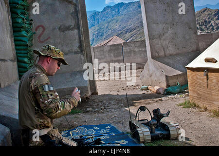 La CPS de l'armée américaine. Andrew B. se Cyborgline un cours de recyclage sur un robot NEM au poste de combat en Honaker-Miracle est de l'Afghanistan, la province de Kunar, 1er août 2011. Clement est un technicien des explosifs et munitions assigné à la 129e Division d'infanterie 25e Compagnie d'artillerie, 3e Brigade Combat Team. Le Sgt. 1re classe Mark Burrell Banque D'Images