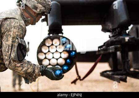 Les soldats du 4e bataillon du 227e Bataillon de Reconnaissance, d'attaque, 1e de cavalerie, maintenant sous la 42e Brigade d'aviation de combat, chargement d'un AH-64 Apache avec 2,75 pouces rockets lors d'un point de ravitaillement en armement de l'avant et de l'exercice avec une compagnie, 642e Bataillon de soutien à l'Aviation, 42e CAB, le 15 janvier 2014, près du Camp Buehring, le Koweït. La 42e CAB, New York, la Garde nationale est basée au Koweït et a pris le commandement de l'aviation de l'armée d'actif dans la région, dans le cadre de l'opération Enduring Freedom. La Garde Nationale de New York photo de la CPS. Harley Jelis Banque D'Images