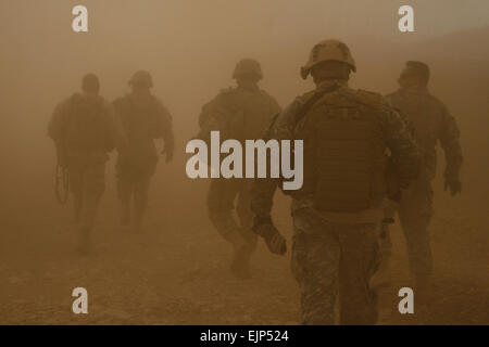 Soldats et marines marcher dans le sillage du rotor d'un hélicoptère Blackhawk UH-60 à mesure qu'ils se dirigent vers la base d'opérations dans le village de Darrah-I-Bum, province de Badghis, l'Afghanistan, le 5 janvier 2011. L'effectif du personnel accompagné le commandement de la Force internationale d'assistance à la sécurité, le sergent sergent-major de commandement. Le major Marvin L. Hill lors d'une visite à la marine, les marins, soldats et d'opérations spéciales de l'Force-West vit et travaille à Darrah-I-Bum. U.S. Marine photo/Sgt. Brian Kester Banque D'Images