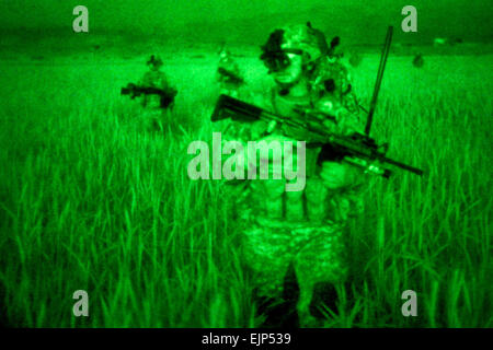 Comme vu par un dispositif de vision de nuit, les soldats de l'armée américaine se déplacer à travers les herbes à un cartel en position Sabari, Khowst province, Afghanistan, 6 avril 2010. Les soldats sont affectés à la 101st Airborne Division de la société D, 3e Bataillon, 187e Régiment d'infanterie, 3e Brigade. Le Sgt. Jeffrey Alexander Banque D'Images