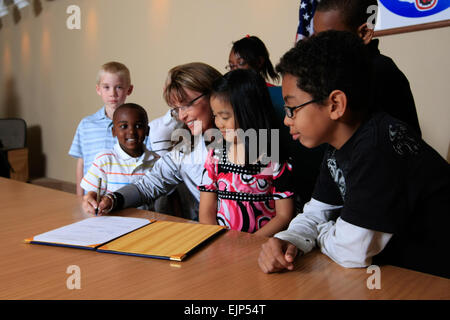 Alaska Gov. Sarah Palin, flanquée par les enfants de l'armée, solennellement signe de Alaska House Bill 137 à Fort Richardson, Alaska, le 18 juin. Cette mesure permet à l'état pour pouvoir rejoindre l'Interstate compact sur les possibilités pour les enfants des militaires, qui a été créé l'année dernière pour faciliter la transition de l'éducation des enfants de militaires et de leurs familles qu'ils partent dans de nouvelles affectations. / / Banque D'Images