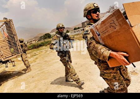 Le Major Andrew Rnaud Dejesse, armée de la stabilité du district d'équipe responsable de l'Équipe de reconstruction provinciale de Laghman, porte une boîte de dons de fournitures scolaires aux enfants dans Alingar disctrict par une classe de New Jersey, le 13 juillet. La mission de l'EPR Laghman a été de rencontrer les dirigeants de district Alingar puis effectuer une inspection finale sur deux projets de construction dans la région. U.S. Air Force photo/ Le s.. Ryan Crane Banque D'Images