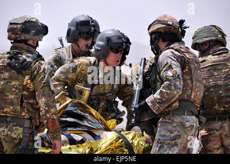 Le personnel médical de vol de la Compagnie Charlie 1-168ème bataillon de l'aviation d'appui général, centre, recueillir des informations auprès des soldats italiens de l'unité de soutien à la transition au sud sur une victime simulée dans le cadre d'une patrouille de route et de démonstration d'évacuation médicale pour l'International Security Assistance Force, Chef d'état-major, le Lieutenant Général Giorgio Battisti lors de sa visite à la base d'opération avancée Farah. L'Équipe de reconstruction provinciale Farah a pour mission de former, de conseiller et d'aider les dirigeants du gouvernement afghan à l'échelle municipale, du district et de la province dans la province de Farah, l'Afghanistan. L Banque D'Images