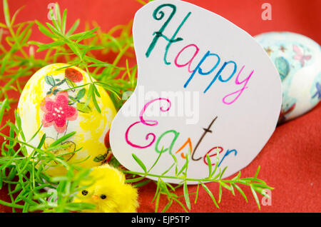 Decoupage peint à la main sur oeufs de Pâques en bois avec une joyeuse Pâques et deux lapins toy Banque D'Images