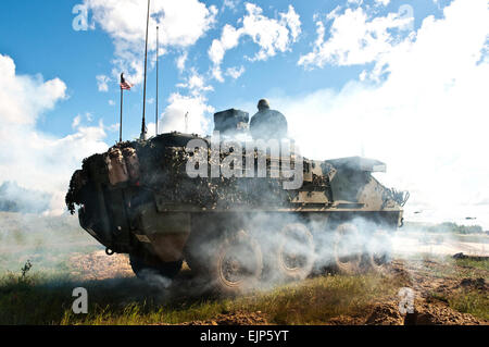 Des soldats américains avec la Compagnie Charlie, 2e Bataillon, 104e régiment de cavalerie, New Jersey Army National Guard déployer la fumée et le feu des mitrailleuses lourdes d'un véhicule blindé au cours d'une bataille de la simulation pour les visiteurs distingués en Lettonie le 17 juin 2014, dans le cadre de la grève 2014 Sabre. Grève de sabre est un U.S. European Command, parrainé par l'état-major interarmées de commandement régional et multilatéral et exercice sur le terrain visant à accroître l'interopérabilité entre les États-Unis et les pays partenaires. La CPS. Joshua Leonard, U.S. Army Banque D'Images