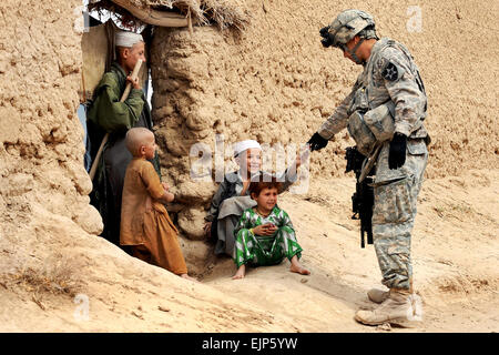 Le sergent de l'armée américaine. Jose Gonzalez donne des collations pour les enfants afghans lors d'une patrouille en Dagyan village dans la province de Helmand, Afghanistan, le 21 février 2010. Gonzalez est attribuée à la société C, 4e Bataillon, 23e Régiment d'infanterie. Le s.. Christine Jones Banque D'Images