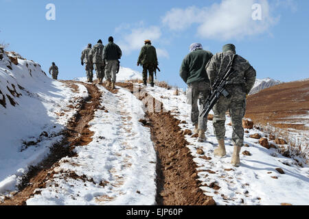 Les membres de l'Équipe de reconstruction provinciale de la police nationale afghane de Ghazni et marcher sur une colline enneigée après leurs véhicules s'est enlisé dans la boue dans l'Nawur district, la province de Ghazni, en Afghanistan, le 8 novembre 2009. Les membres de l'équipe a visité le district d'effectuer un contrôle d'assurance qualité sur un karza et deux cliniques de santé globale. Le Sgt Tech. Rebecca F. Corey Banque D'Images