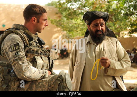 Le capitaine de l'armée américaine Maxwell Pappas, district de gauche chef de l'unité de soutien de l'Équipe de reconstruction provinciale de Zaboul, parle avec joie Shah Abdul Qayum Chef de district avant d'une shura près de la base d'opération avancée Bullard dans province de Zabul, Afghanistan, le 7 septembre 2010. Au cours de la shura, Qayum a parlé pour les anciens, pour les prochaines élections parlementaires provinciaux. Airman Senior Nathanael Callon, U.S. Air Force. Publié Banque D'Images