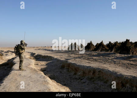 Une opération des Forces spéciales Detachment-Alpha SFODA analyse la zone en tant que soldat de l'Armée nationale afghane ANA Commandos, 2e compagnie, 3e Kandak d'opérations spéciales du jeu de conduite SOK Mandozai village, district de Maiwand, province de Kandahar, Afghanistan, le 27 décembre 2013. L'SFODA a aidé le 3ème SOK dans la réalisation d'un dégagement pour perturber l'utilisation des insurgés de Mandozai village comme un lit. Le sergent de l'armée américaine. Bertha A. Flores Banque D'Images