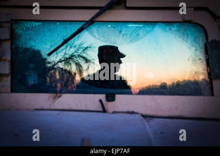 Un soldat de la 36e Division d'infanterie, Texas Army National Guard observe une section de la rivière Rio Grande au coucher du soleil à l'appui de l'opération de sécurité solide. La photo a été prise à l'aide de la réflexion sur le pare-brise d'un Humvee "M114" à la frontière Texas-Mexique. Le major Randall Stillinger Banque D'Images