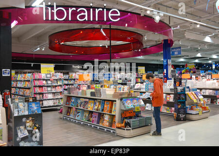 Belgique - Octobre 2014 : garçon est en train de lire un livre de bandes dessinées à la librairie section dans un hypermarché Carrefour en Belgique Banque D'Images