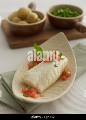 Plaqué simple repas de plaine poêlées filet d'aiglefin et de la morue avec tomate et basilic haché pommes de terre nouvelles bouillies Banque D'Images