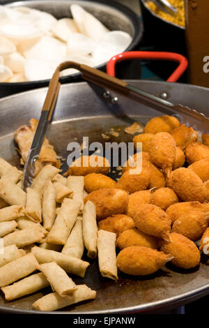 Cuisson des aliments chinois dans les casseroles sur un étal à Camden Londres Banque D'Images