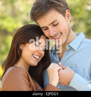 Couple hugging et tenir la main tout en l'air une bague de fiançailles à l'extérieur Banque D'Images