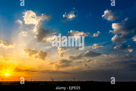 Coucher du soleil orange avec ciel bleu et nuages blancs. Banque D'Images