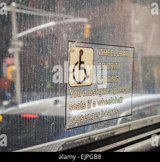 Un signe de places prioritaires réserver des places pour les personnes en fauteuil roulant est vu sur un bus de New York le dimanche 22 mars, 2015. (© Richard B. Levine) Banque D'Images