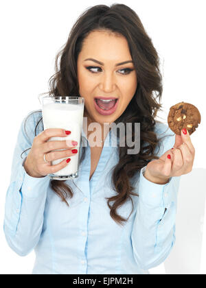 Jolie jeune femme avec un verre de lait et biscuit Banque D'Images