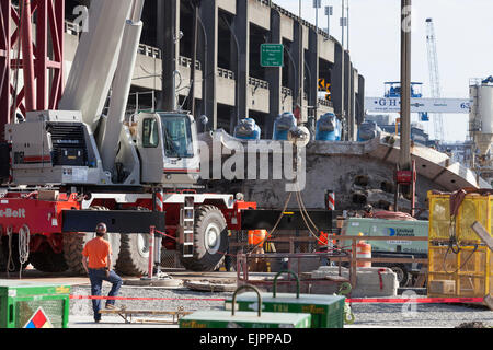 Seattle, Washington, USA. 30Th Mar, 2015. Crane lève le visage de coupe le plus grand tunnel-aléseuse de la surface de réparation - le 30 mars 2015. Le tunnelier, surnommé Bertha, a été retardé depuis décembre 2013 après une surchauffe en raison des dommages causés à l'entraînement de la tête de coupe, les roulements et les joints. Ce retard a duré plus d'un an, car les travailleurs qui ont creusé un puits vertical de 120 pieds vers le bas la tête de coupe pour la réparer. Creuser devrait reprendre en août, une fois les réparations terminées. Crédit : Paul Gordon/Alamy Live News Banque D'Images