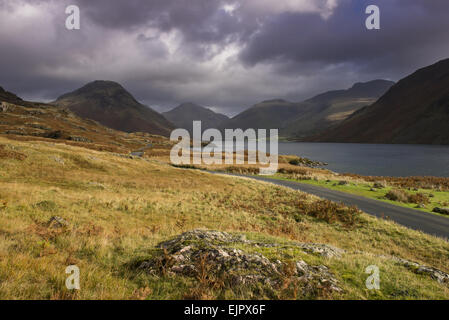 Vue du lac en "sur-approfondi' vallée glaciaire, lac le plus profond de l'Angleterre à 79 mètres (258 pieds), avec Red Pike Peak et la route qui serpente vers Wasdale Head en arrière-plan, Wastwater, Wasdale, Lake District N.P., Cumbria, Angleterre, octobre Banque D'Images