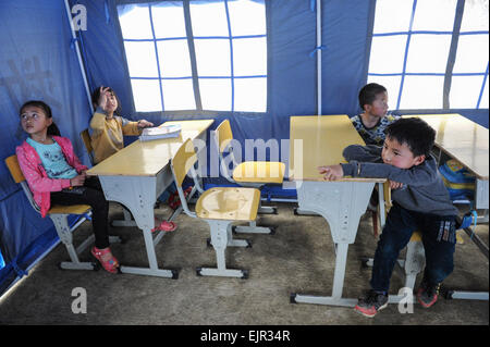 Jianhe, province du Guizhou en Chine. Mar 31, 2015. Les enfants sont assis dans un camp de fortune à Xinliu Village de Jianhe, comté de la province du Guizhou, au sud-ouest de la Chine, 31 mars 2015. Les gens de la région ont commencé la reconstruction post-catastrophe le deuxième jour après un séisme de magnitude 5,5 a frappé le comté de Jianhe lundi. Credit : Ou Dongqu/Xinhua/Alamy Live News Banque D'Images