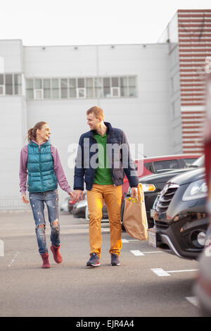 Couple walking after shopping près des voitures Banque D'Images
