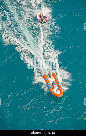 Jouet gonflable remorqué derrière un bateau de vitesse pendant l'été tropical sea holiday vacation Banque D'Images