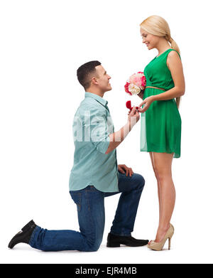 Smiling couple avec bouquet de fleurs et de l'anneau Banque D'Images