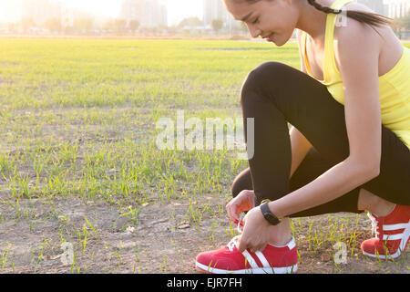 Jeune femme attacher les lacets Banque D'Images