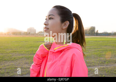 Young woman zipping up hoodie Banque D'Images