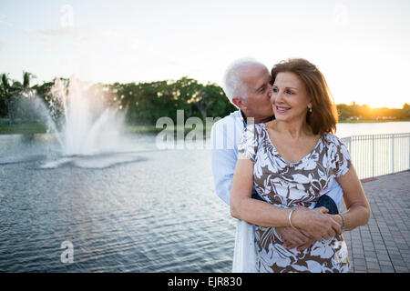 Caucasian couple hugging by fountain Banque D'Images